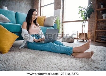 Photo of concentrated lady worker freelancer using netbook typing letters speak with colleagues cliets in living loft room