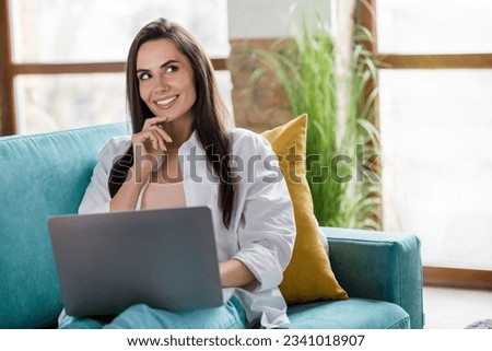 Photo of clever lady freelancer sitting cozy couch using netbook thinking solving work tasks in apartment flat interior Royalty-Free Stock Photo #2341018907