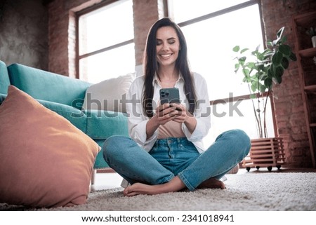 Photo of positive millennial lady use device apple iphone pro max writing letters in web app forum in flat loft house
