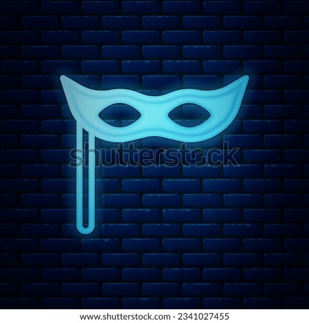 Glowing neon Festive mask icon isolated on brick wall background. Merry Christmas and Happy New Year.  Vector