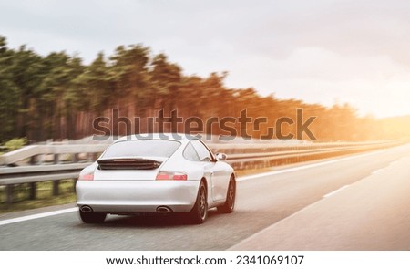 Silver German roadster coupe on the highway. Silver sport coupe. Expensive sports car rushing along the highway Royalty-Free Stock Photo #2341069107