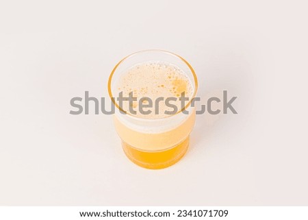 Orange vitamin C effervescent tablet dropped and dissolve in glass of water with bubbles isolated on white background