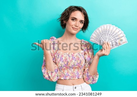 Photo of charming lovely person arm hold dollar bills indicate finger empty space isolated on teal color background