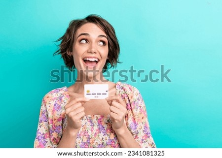 Photo of astonished nice person arms hold plastic debit card look empty space isolated on teal color background