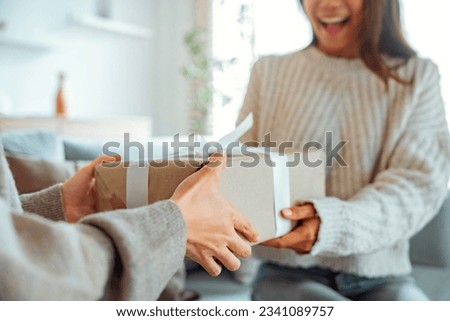 Excited asian woman getting surprise gift from her girlfriend at home. Gives a gift, birthday gift, New year day celebration and congratulation