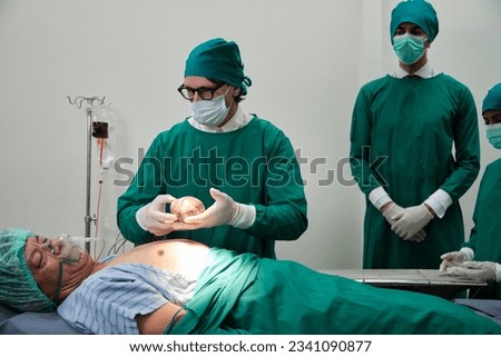 Practitioner doctors give the heart to specialist surgeons for change, medical technology, professional surgery operations on critically ill patients in hospital's ICU, and paramedic occupation. Royalty-Free Stock Photo #2341090877