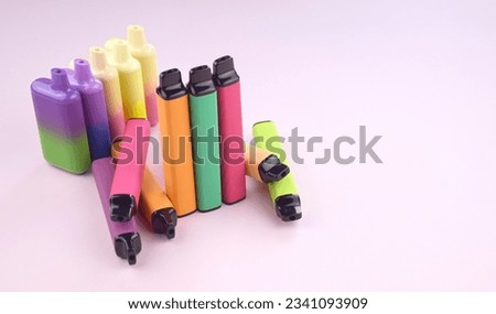 Set of multicolor disposable electronic cigarettes on a pink background. The concept of modern smoking, vaping and nicotine.