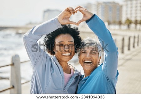 Heart, hands and fitness with portrait of friends at beach for health, support and love. Motivation, happy and wellness with mature women and sign in nature for exercise, workout and emoji icon