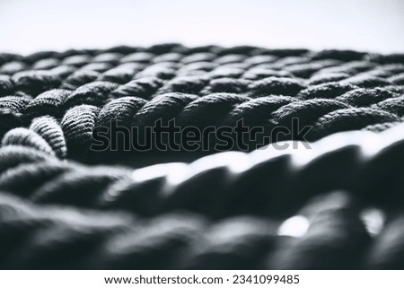 Close up of black battle rope on a gray backgound. Sport and fitness equipment. Royalty-Free Stock Photo #2341099485
