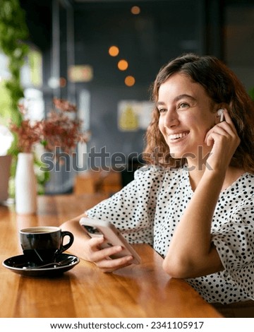 Businesswoman Wireless Streaming Music Wearing Earbuds Working In Coffee Shop Or Office