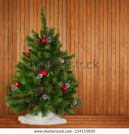 Green Decorated Christmas Tree on Wooden Background. Closeup.