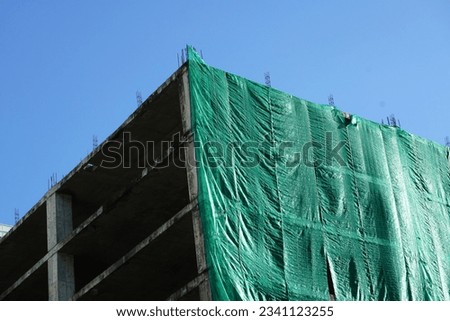 Shading Net was used for temporary wall around construction site. Green Shading Net and green metal sheet fence prevents dust from construction site.