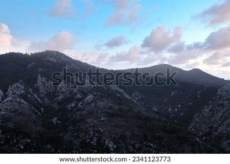 Mountain landscape at sunset . Clouds over the mountain peak 