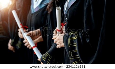 Graduated students holding diplomas in a line Royalty-Free Stock Photo #2341126131