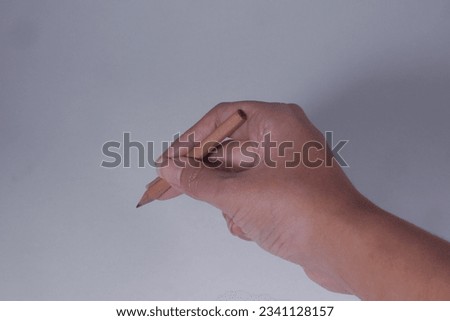 Hand holding small wooden pencil to write and learn, isolated on white background