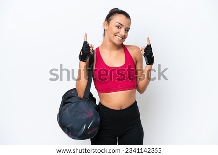 Young sport woman with sport bag isolated on white background pointing up a great idea
