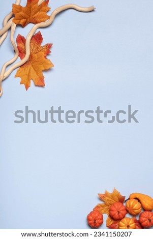 Blue background with autumn leaves and wooden branches. Copy space. Royalty-Free Stock Photo #2341150207