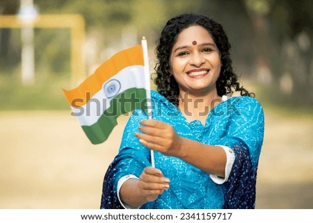 Indian woman waving national tricolor flag Royalty-Free Stock Photo #2341159717