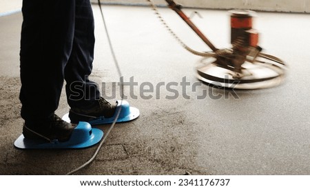 Finishing concrete floor with trowel machine tool Royalty-Free Stock Photo #2341176737