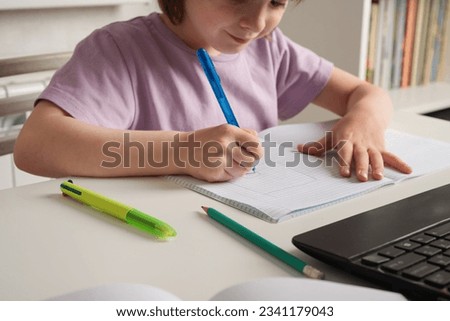 Close-up of children's hands. Left-hander writes in a notebook on the table. International Left Handers Awareness Day Royalty-Free Stock Photo #2341179043