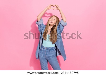 Photo portrait of attractive young teen woman raise hands heart shape look dressed stylish denim clothes isolated on pink color background