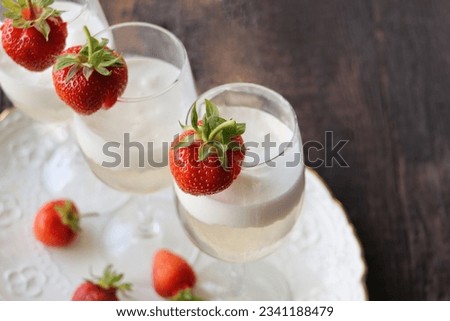 Glass of strawberry cocktail or mocktail, refreshing summer drink with champagne, strawberries, ice cream
