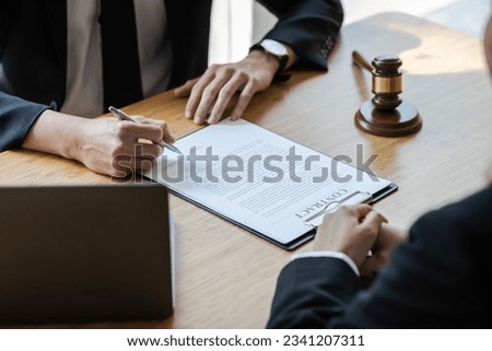 Lawyer is explaining the terms of the legal contract document and asking the client to sign it properly. Legal counsel and legal proceedings consulting services. Royalty-Free Stock Photo #2341207311
