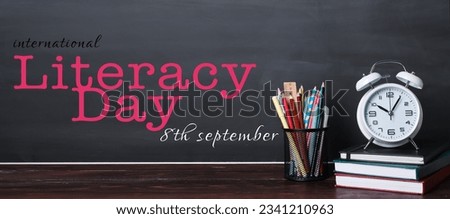Banner for International Literacy Day with alarm clock and school stationery Royalty-Free Stock Photo #2341210963