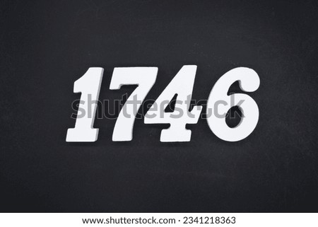 Black for the background. The number 1746 is made of white painted wood. Royalty-Free Stock Photo #2341218363