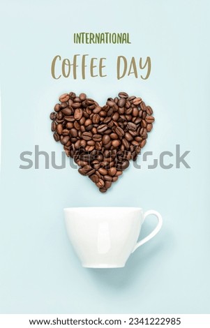 White cup and coffee beans on blue background, international coffee day concept