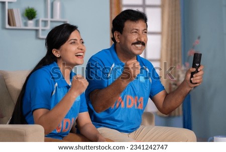 focus on father, Excited joyful father with daughter celebrating India's win while watching Cricket live sports match on tv or television at home - concept of Proud Moment, Cricket fever and Happy