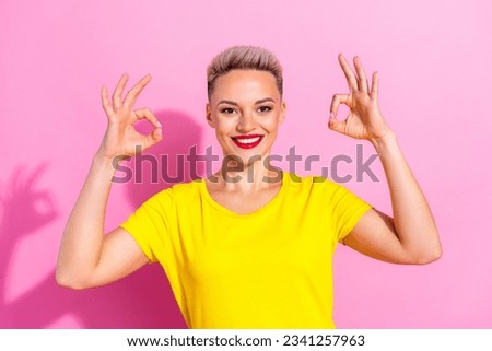 Photo of cute cheerful girl toothy smile arms fingers demonstrate okey symbol approval isolated on pink color background