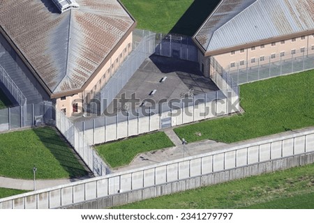 An aerial view of a HMP prison taken from a helicopter in the United Kingdom. Her Majesties Prison has fences and barbed wire preventing the escape of the jails inmates Royalty-Free Stock Photo #2341279797