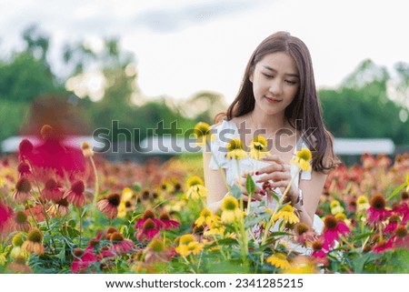Beautiful Asian woman in a garden with beautiful colorful flowers Asian woman nature while relaxing in a flower garden, Chiang Mai, Thailand