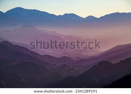 A graphic gradient mountain scene with blue and magenta colors in the morning