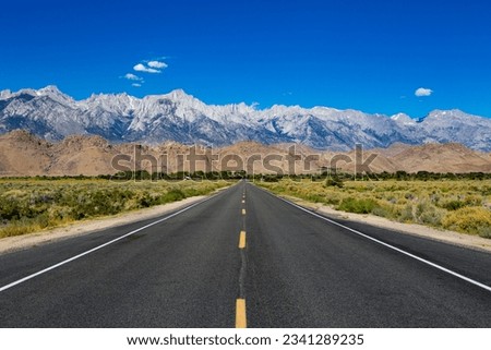The middle of the road looking at the High Sierras and Mt Whitney in California