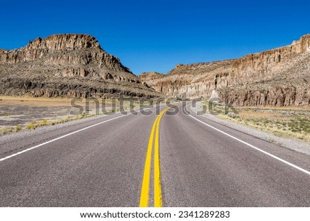 A road trip scene from south west Utah with bright yellow median right downt eh middle
