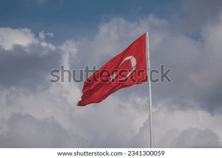 The Turkish flag waving in the wind in the summer season in the blue sky