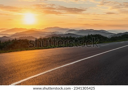 A road in a mountainous area. Beautiful mountain landscape. View of the highway in the mountainous area. Beautiful road background. Road landscape in beautiful nature. Sunset, sunrise Royalty-Free Stock Photo #2341305425
