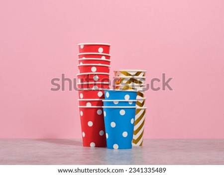 Paper cups with different pictures are on the table. Cocktails, celebratory drinks and alcohol.