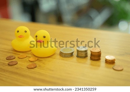 yellow rubber duck Two small figures, placed side by side, with coins lined up vertically.
