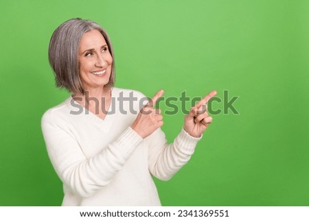 Photo of attractive pensioner woman lady direct fingers empty space show novelty ads wear white shirt isolated green background