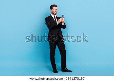 Full length photo of positive attractive advisor dressed black suit communicating modern device isolated blue color background