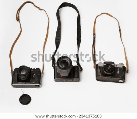 three Old, aged film cameras in black leather cases isolated on white background. 3 Vintage soviet union photo cameras. made in USSR.