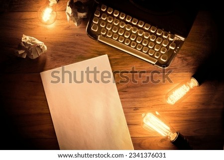 A Vintage Typewriter on a wooden table with lightbulbs and writing paper.