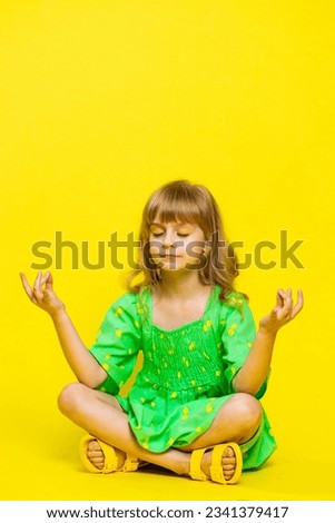 Keep calm down. Blonde child girl kid breathes deeply with mudra gesture, eyes closed, meditating with concentrated thoughts, peaceful mind, relaxing, taking a break, rest. Preteen children. Vertical