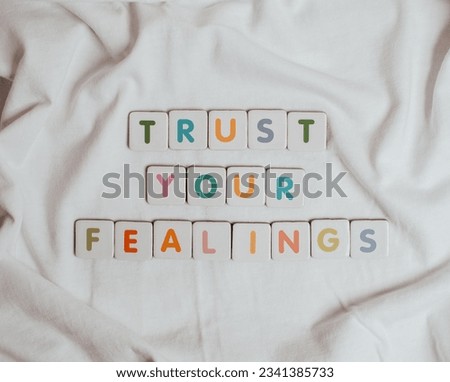 Motivational Message on White Textile.
Trust Your Feelings.
Inspiration Quote.
