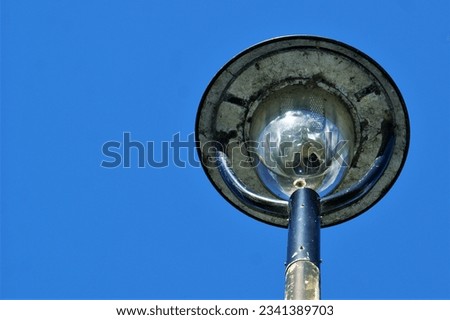Old modern style lantern on sky background on sunny day. View from below close-up.