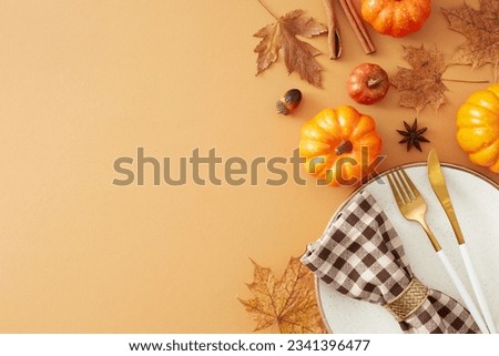 Festive autumn table setting idea. Top view shot of plate, cutlery, pumpkins, dry leaves, checkered napkin, anise, cinnamon sticks, acorns on pastel brown background with blank space for ads or text
