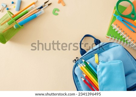 Preparing for elementary school start. Top view composition of school supplies, blue schoolbag, colorful letters on pastel beige background with empty space for advert or message Royalty-Free Stock Photo #2341396495